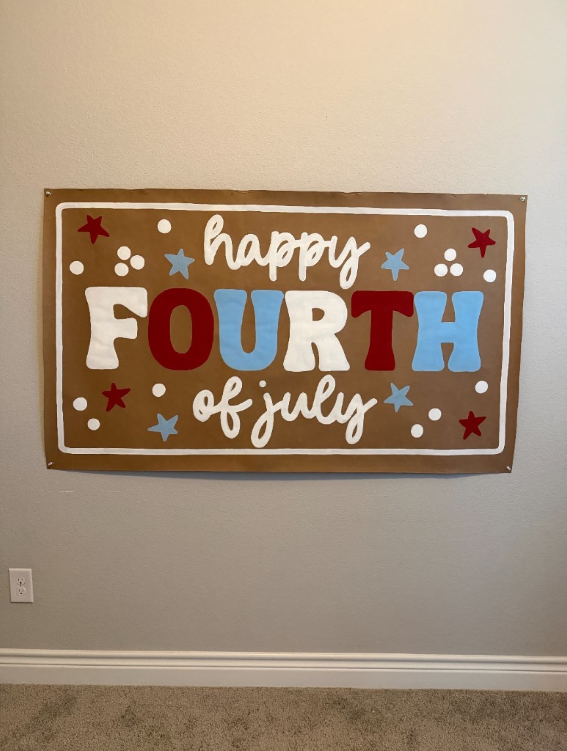 Kraft paper banner reading Happy Fourth of July with red, white, and blue letters, stars, and dots