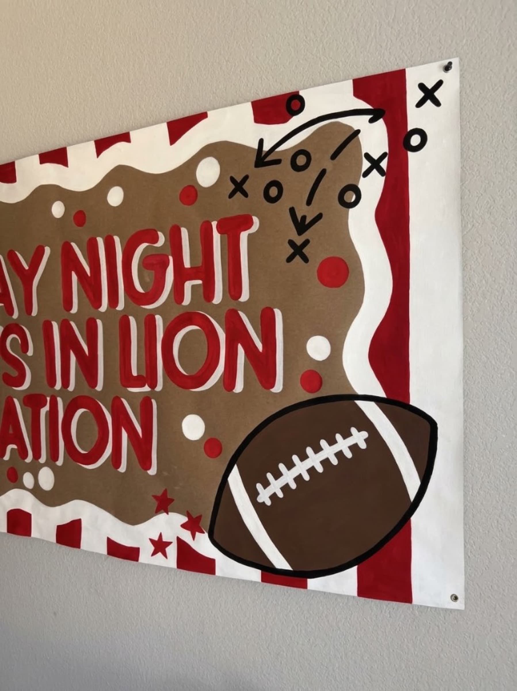 Opposite corner of the same banner with a metal grommet beside a painted football