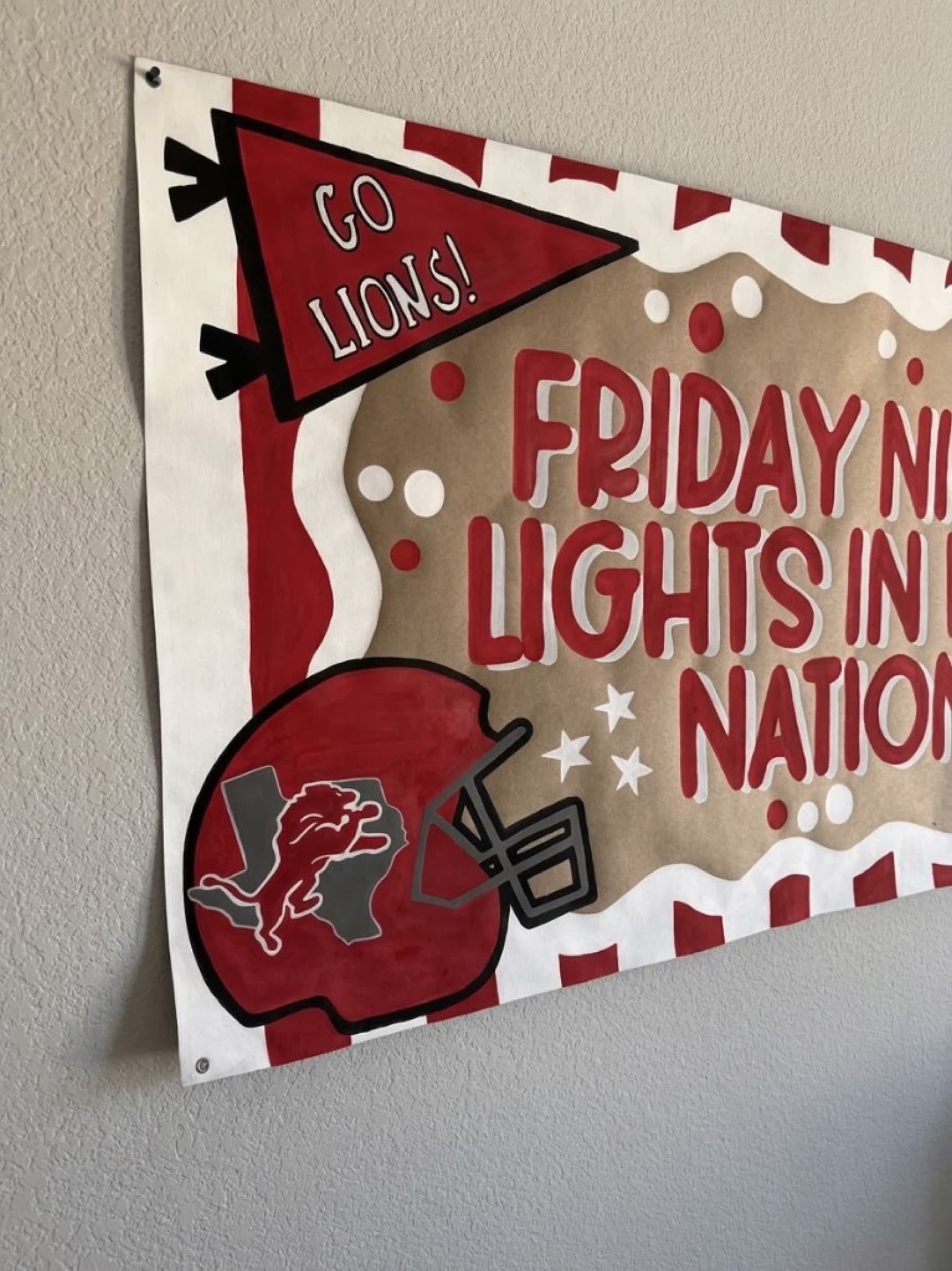 Corner of a Kraft football banner with a metal grommet beside a painted helmet